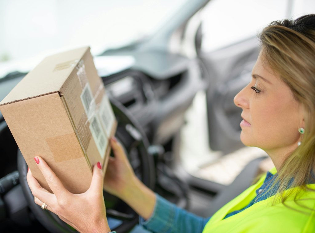 Delivery Woman in Van Checking address on parcel